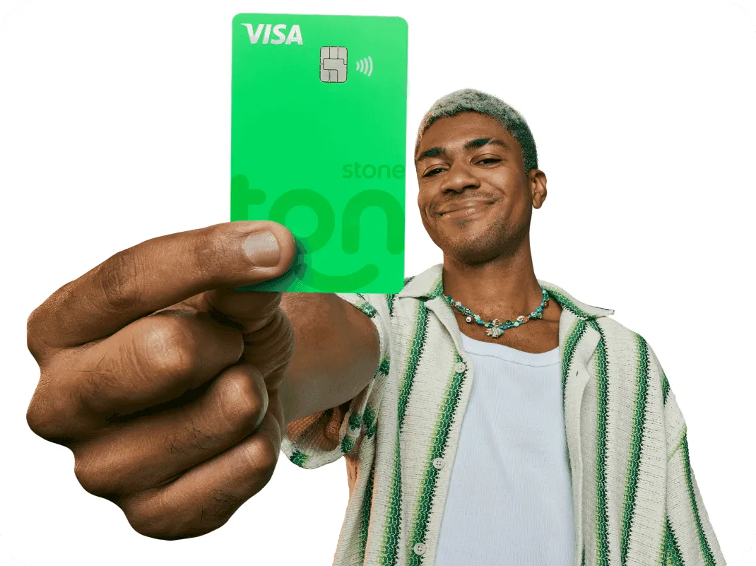 Empreendedor segurando o cartão Crédito e débito do Ton na sua frente com uma mão.