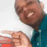 Empreendedor Everton sorrindo e sinalizando com a mão para o lado esquerdo