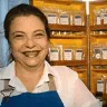 Empreendedora Simone Viana sorrindo e atrás uma prateleira de produtos